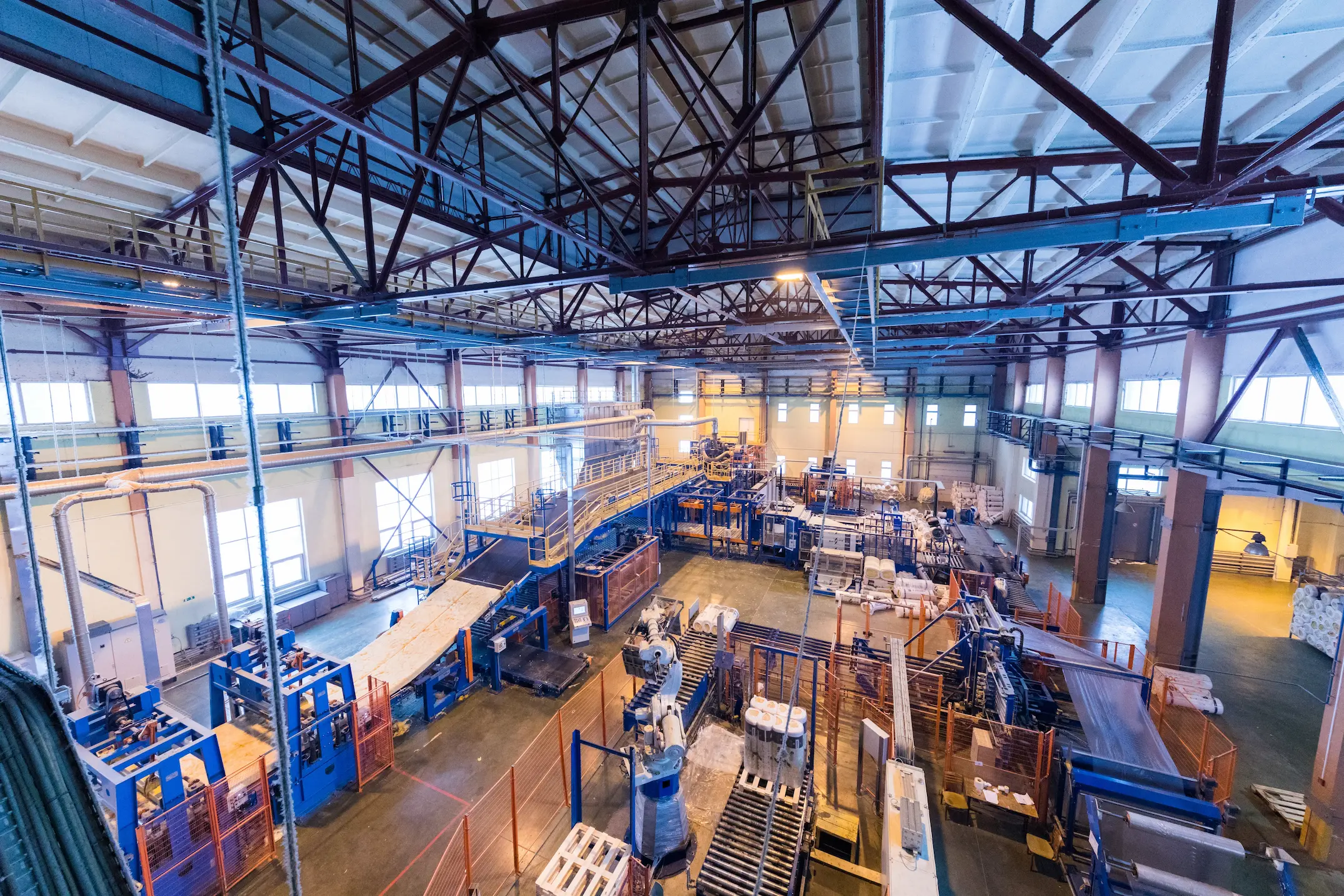 Workers in protective gear operating machinery inside an industrial plant